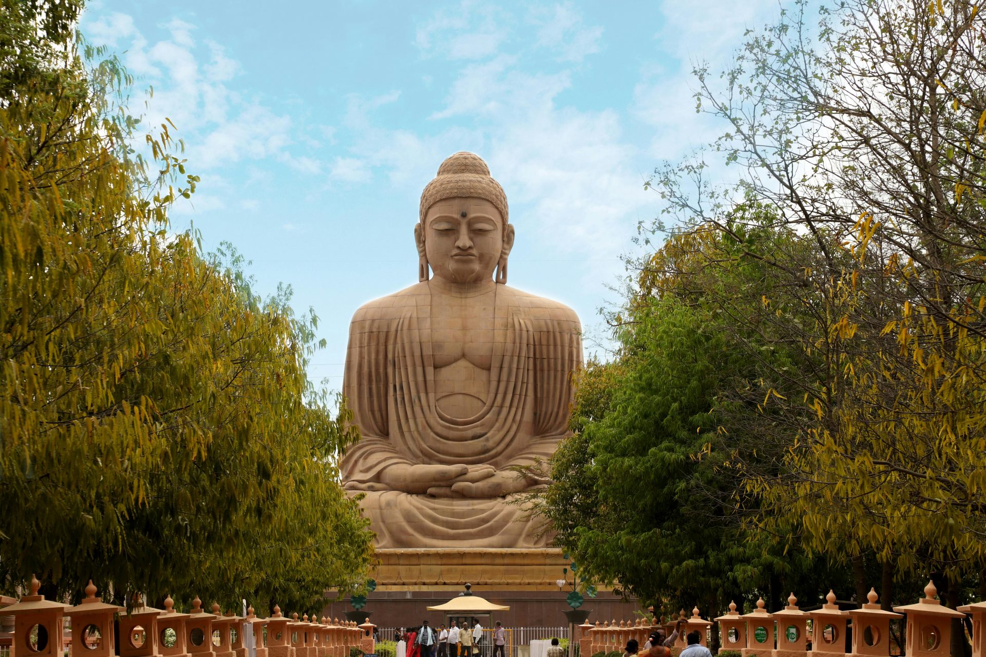 An awe-inspiring view of the Great Buddha Statue in Bodh Gaya, surrounded by lush greenery.